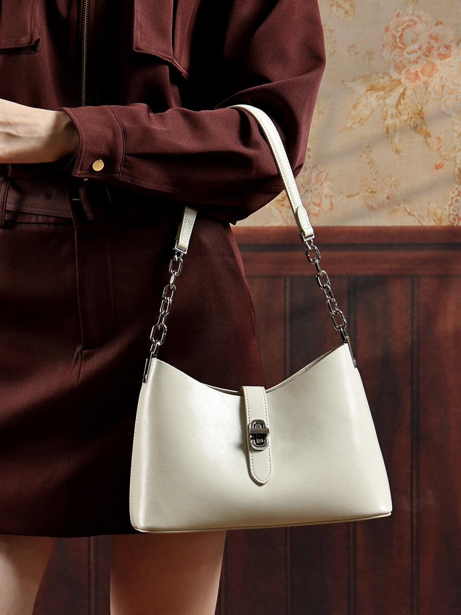 Sac Fanny crème porté au bras avec un manteau bordeaux