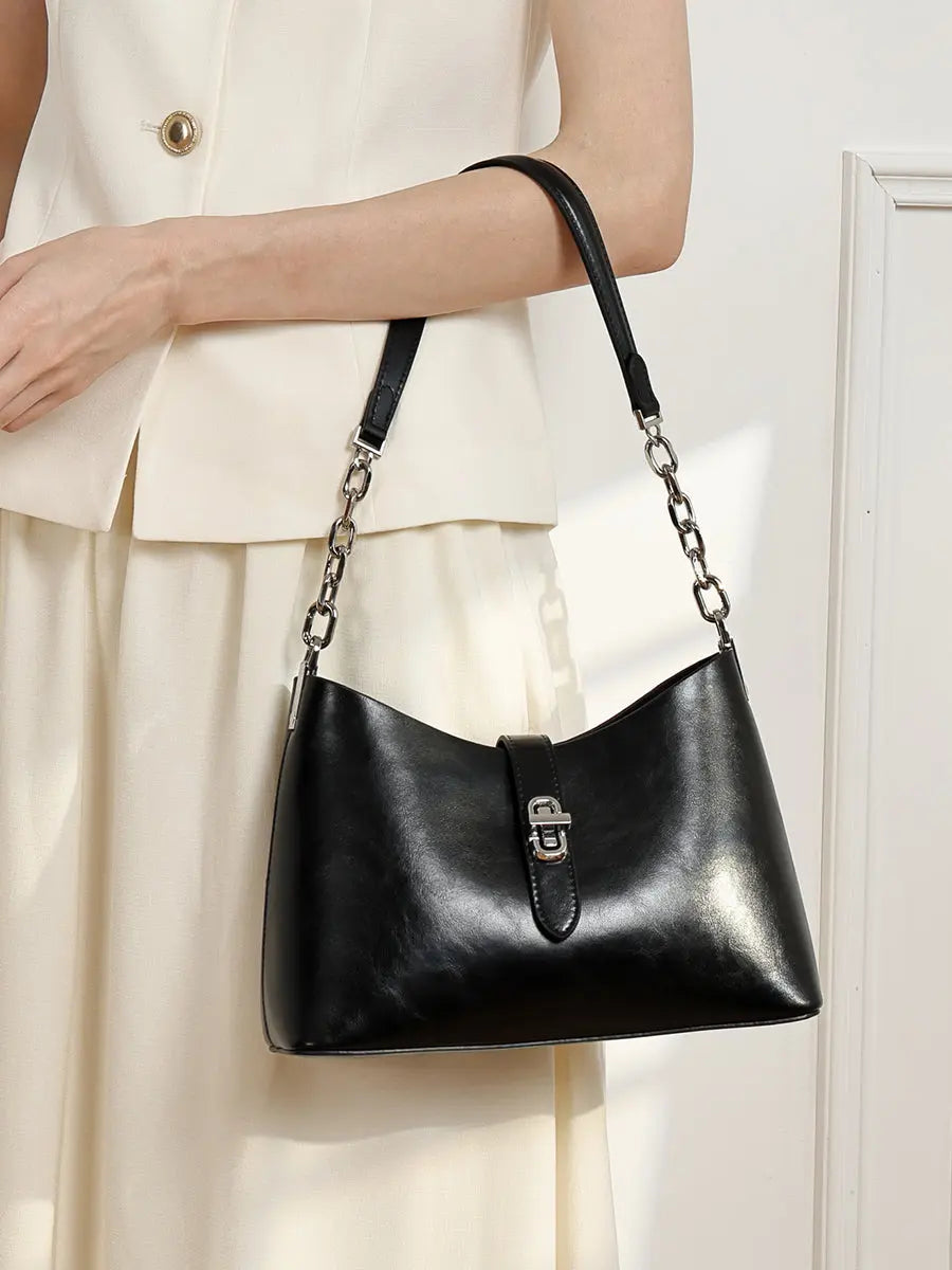 Sac Fanny noir porté au bras avec une tenue crème