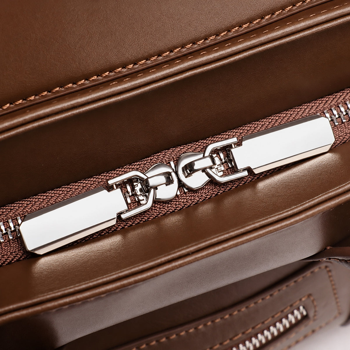 Gros plan sur le double zip et les coutures du cuir Café