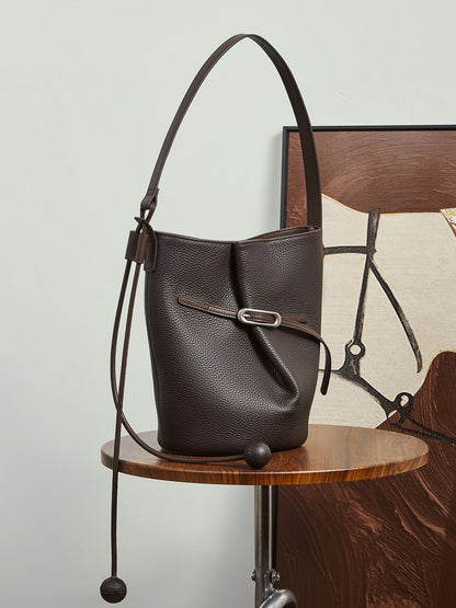Sac Isabella marron café posé sur une chaise devant un tableau
