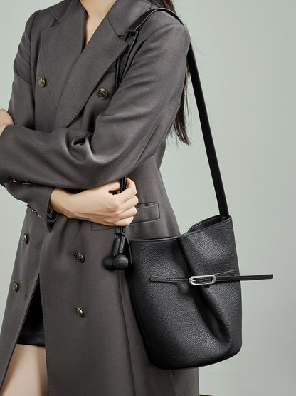 Sac Isabella noir porté à l’épaule avec un manteau gris