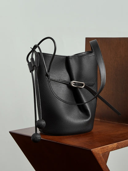 Sac Isabella noir posé sur une chaise en bois