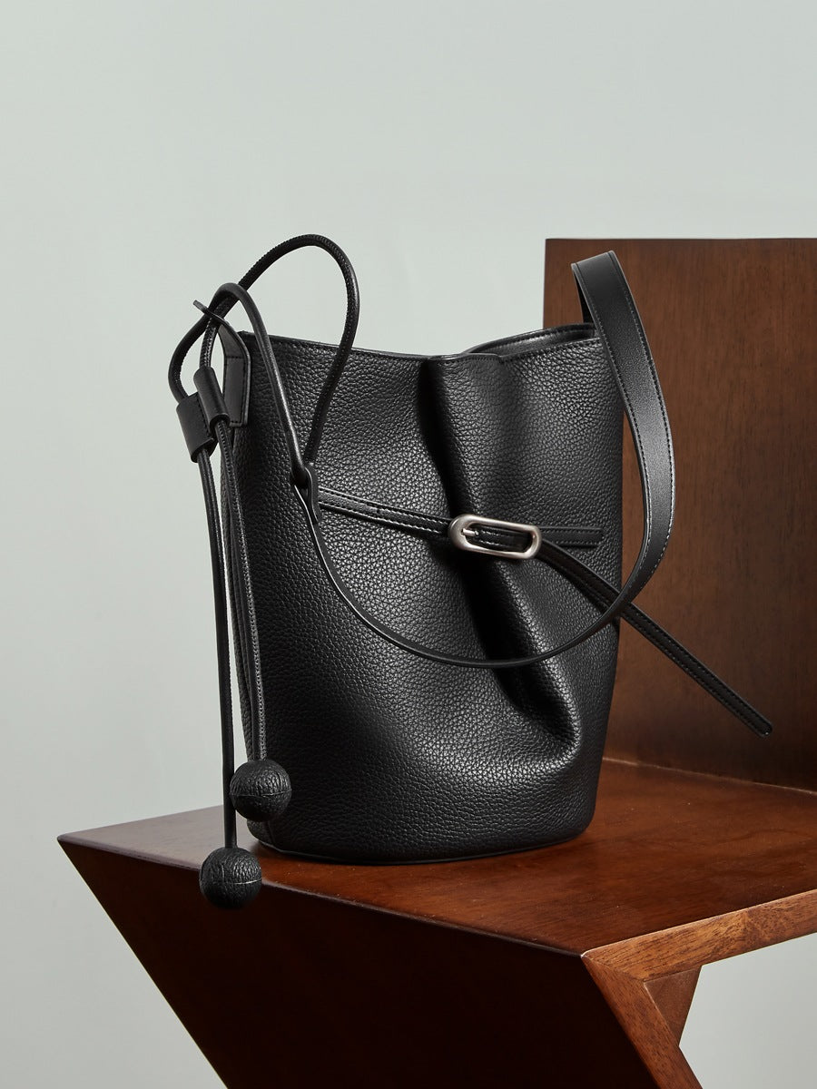 Sac Isabella noir posé sur une chaise en bois