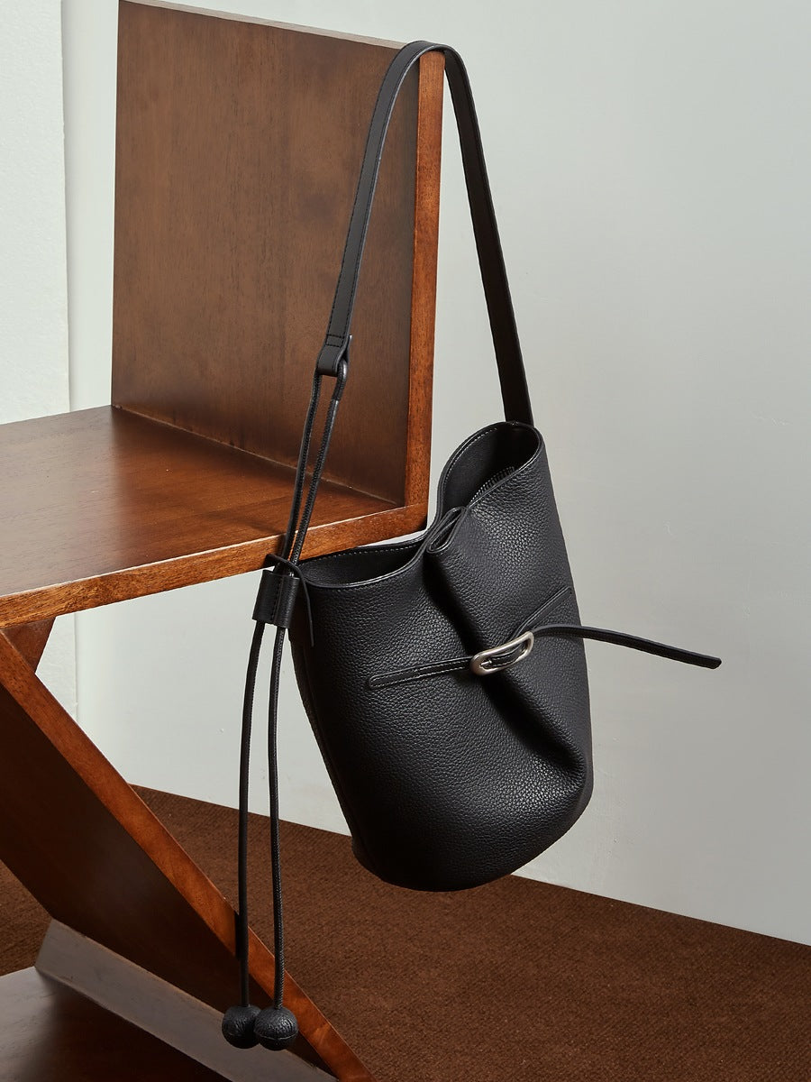 Sac Isabella noir suspendu par sa bandoulière à une chaise