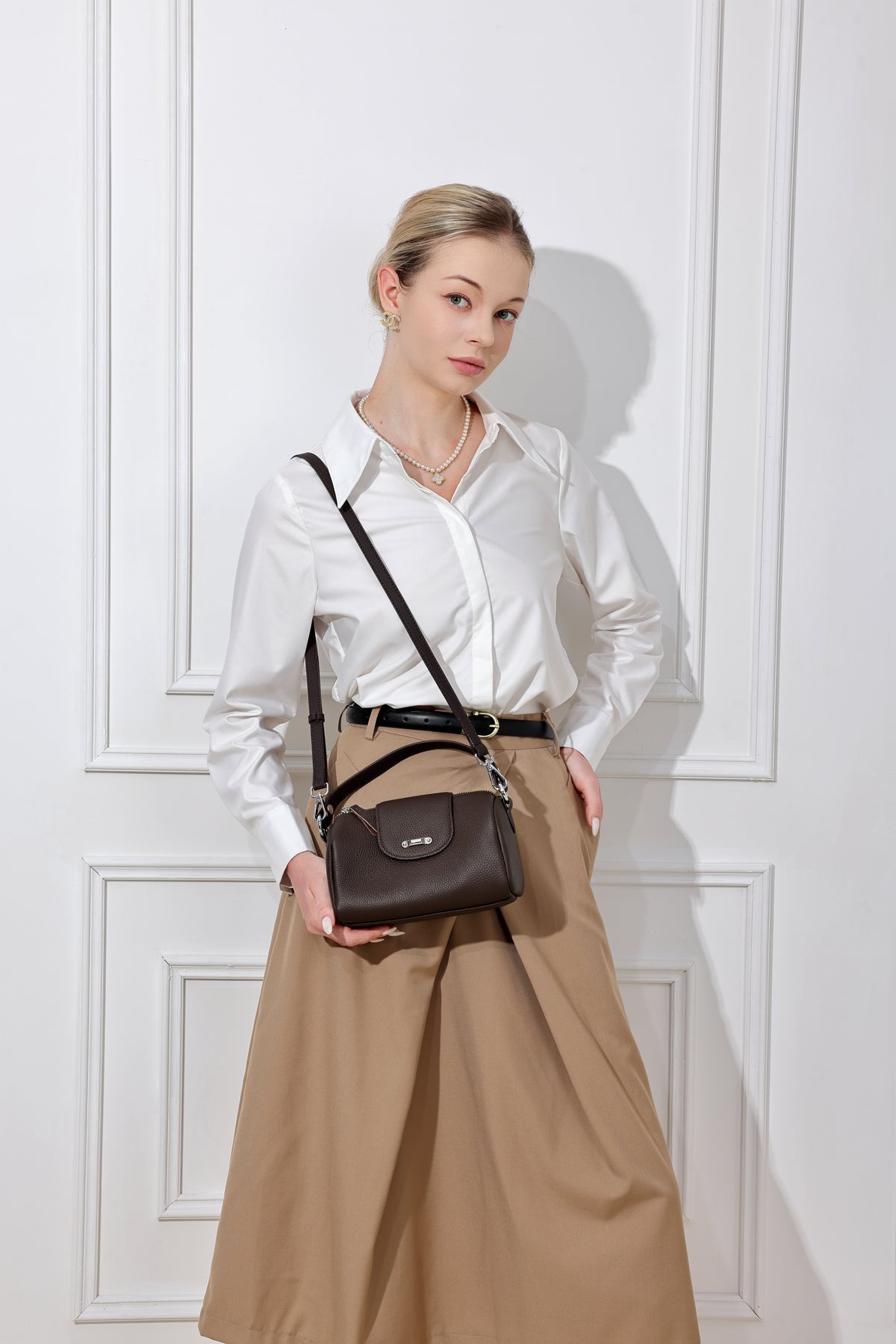 Lana chocolat porté en bandoulière avec une chemise blanche