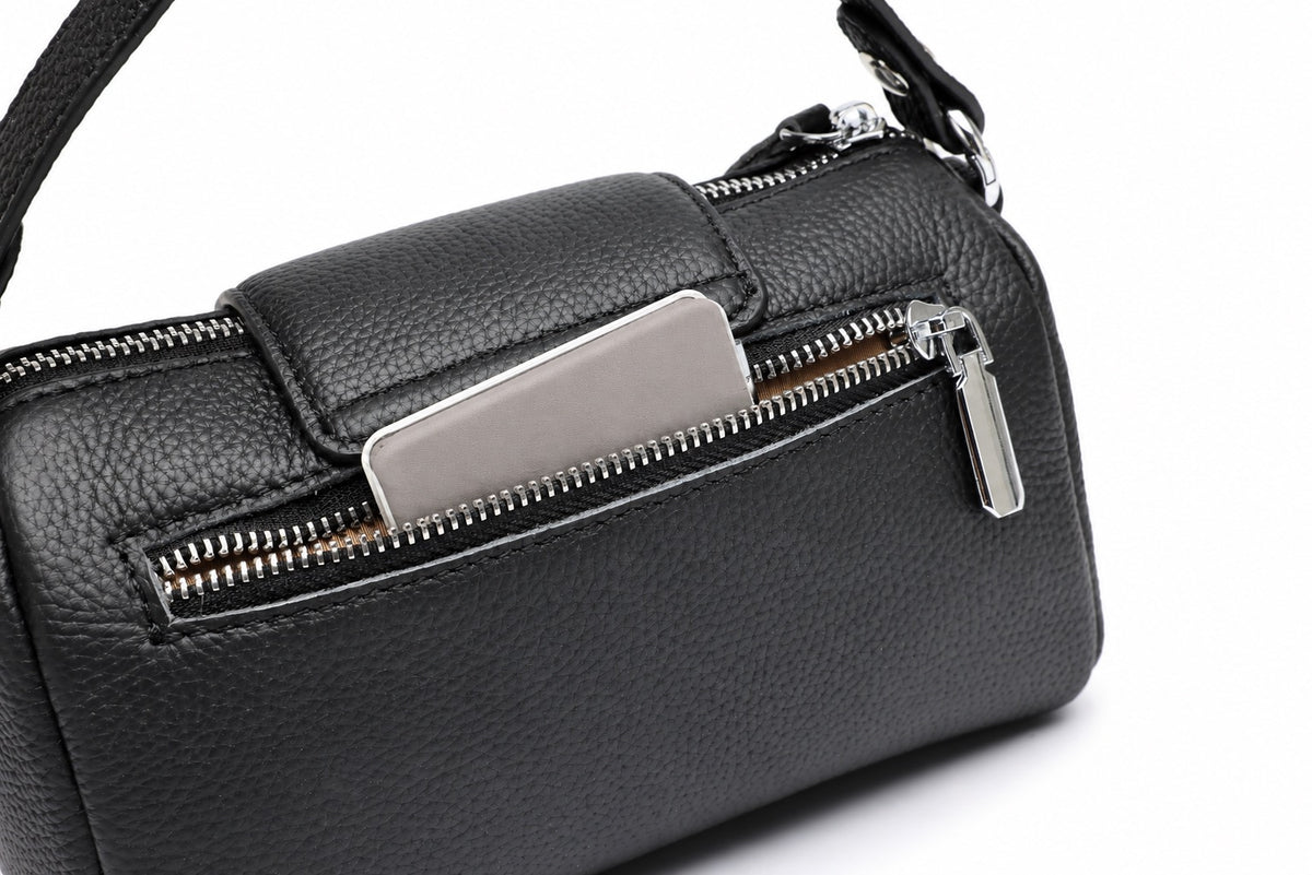 Gros plan de la poche arrière zippée de Lana, cuir grainé noir et finitions argentées