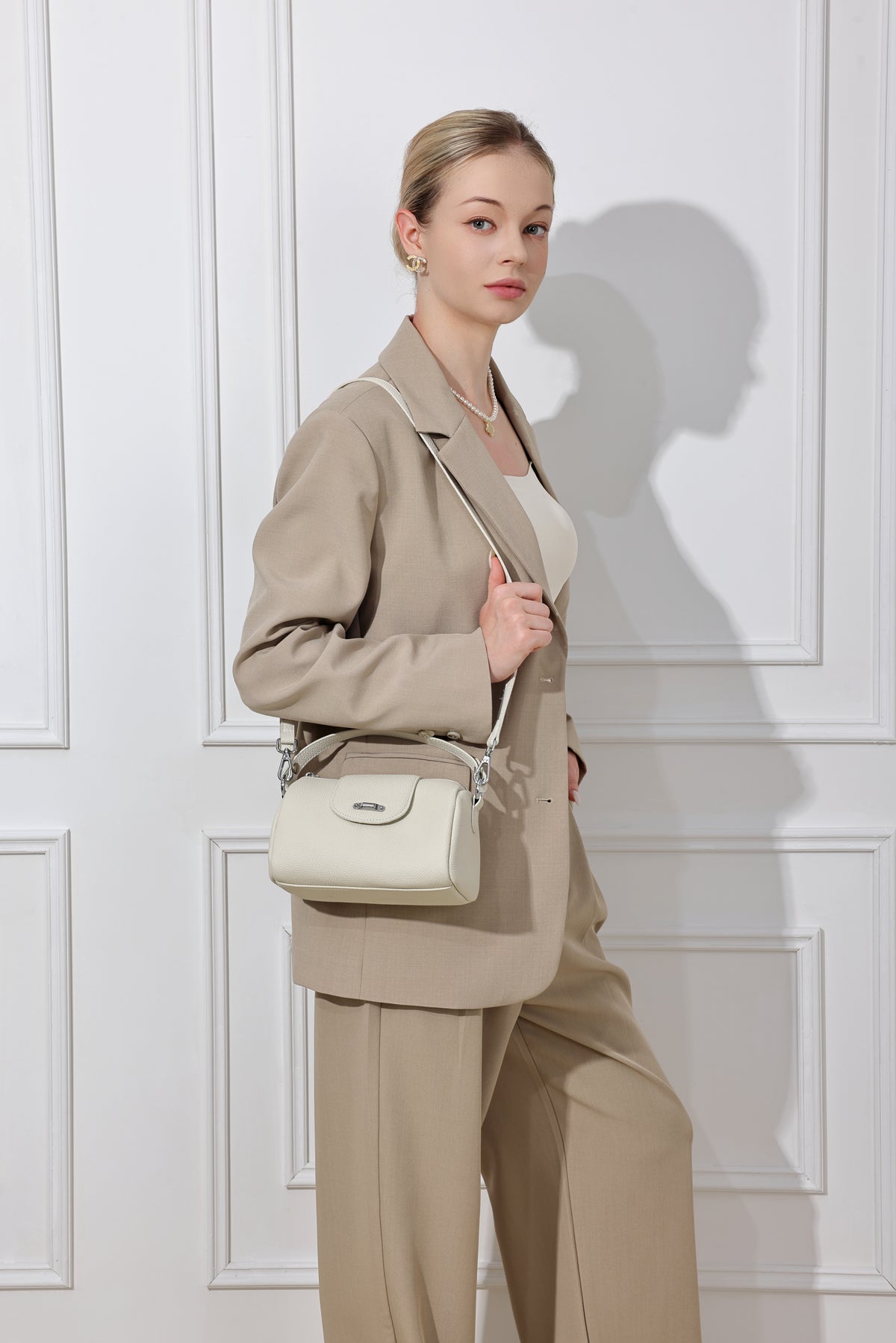 Lana ivoire porté à l’épaule avec un tailleur beige