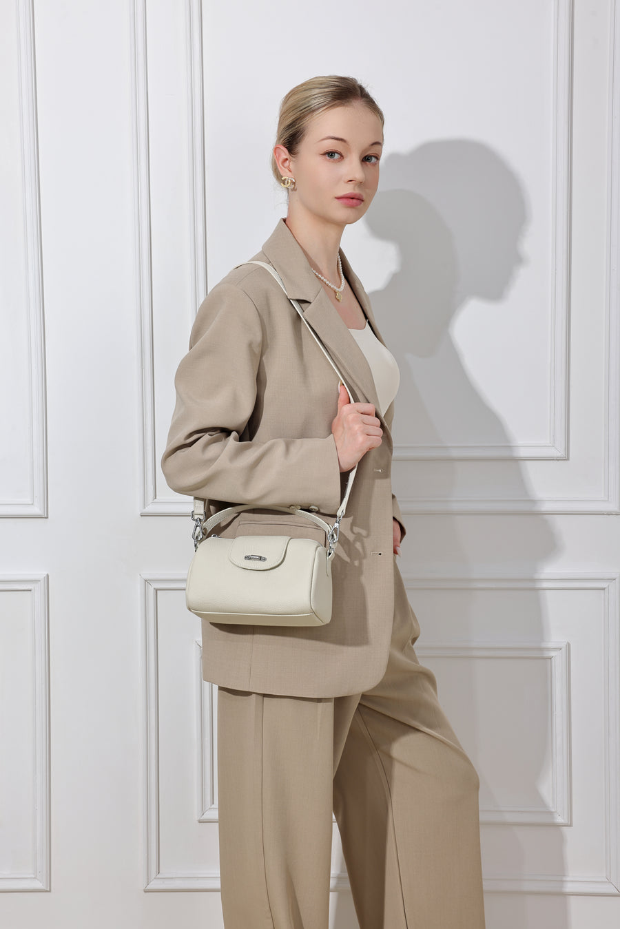 Lana ivoire porté à l’épaule avec un tailleur beige