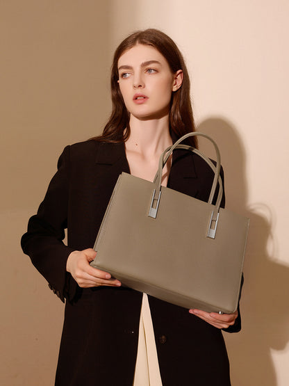 Sac Melinda taupe tenu devant soi par un modèle en blazer noir