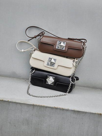 Les trois coloris du sac Monica : caramel, crème et noir, sur une table