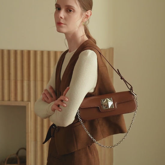Présentation du sac Monica en noir, crème et caramel, porté à la main et à l’épaule