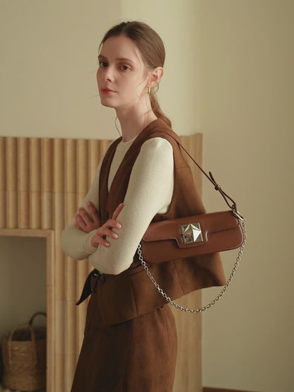 Présentation du sac Monica en noir, crème et caramel, porté à la main et à l’épaule