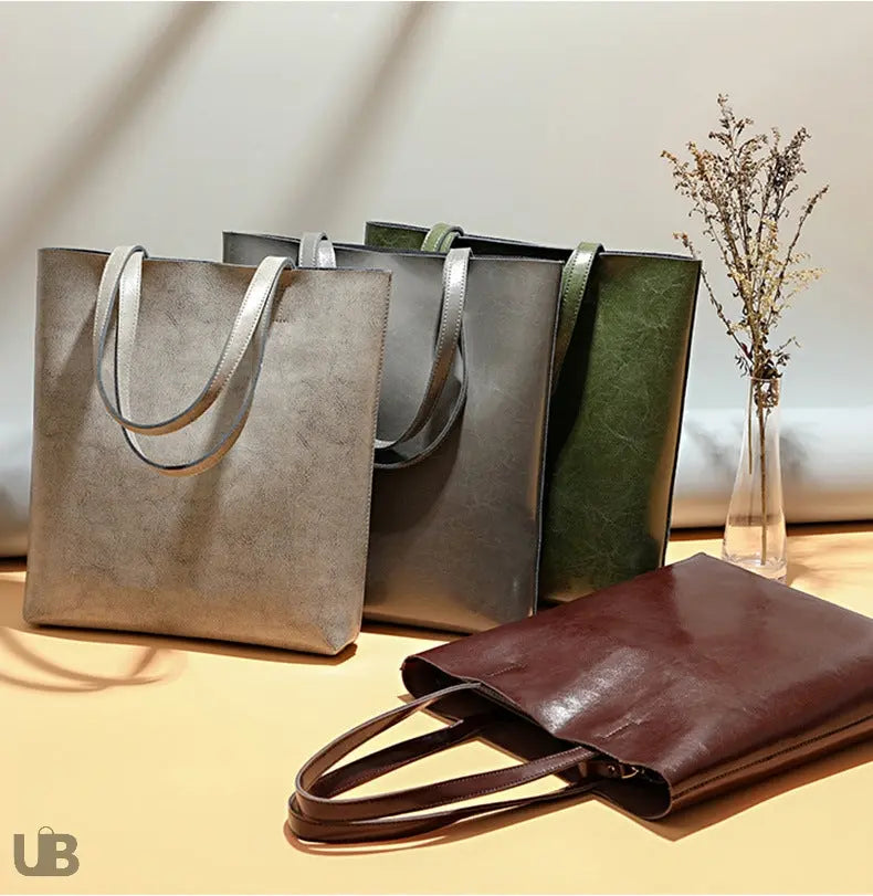 sac fourre tout luanda en cuir cire a l huile universbags jpg gris gris clair vert et cafesur un fond blanc posés sur un meuble 4 sacs avec accessoire de décoration