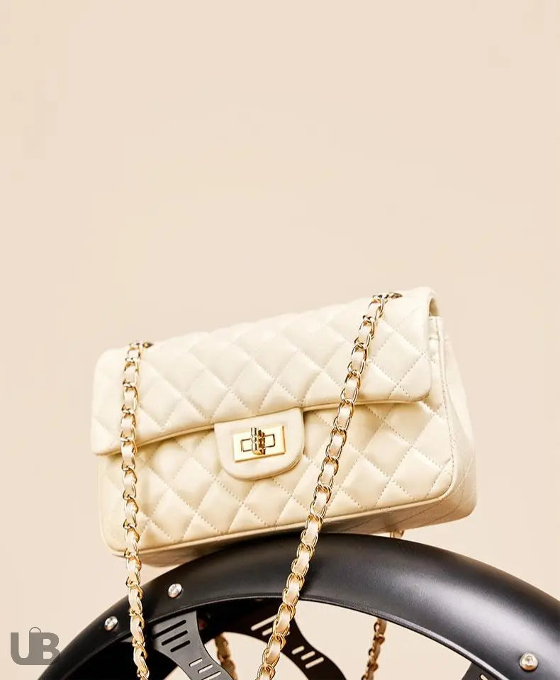 sac à main blanc crème Zephyr en cuir posé sur un garde boue de moto sur fond beige