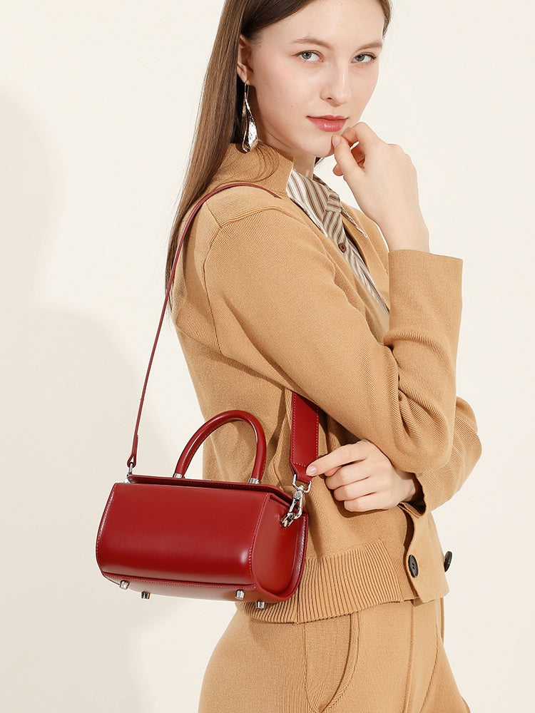 Petit sac Selena rouge porté à l’épaule avec une tenue camel