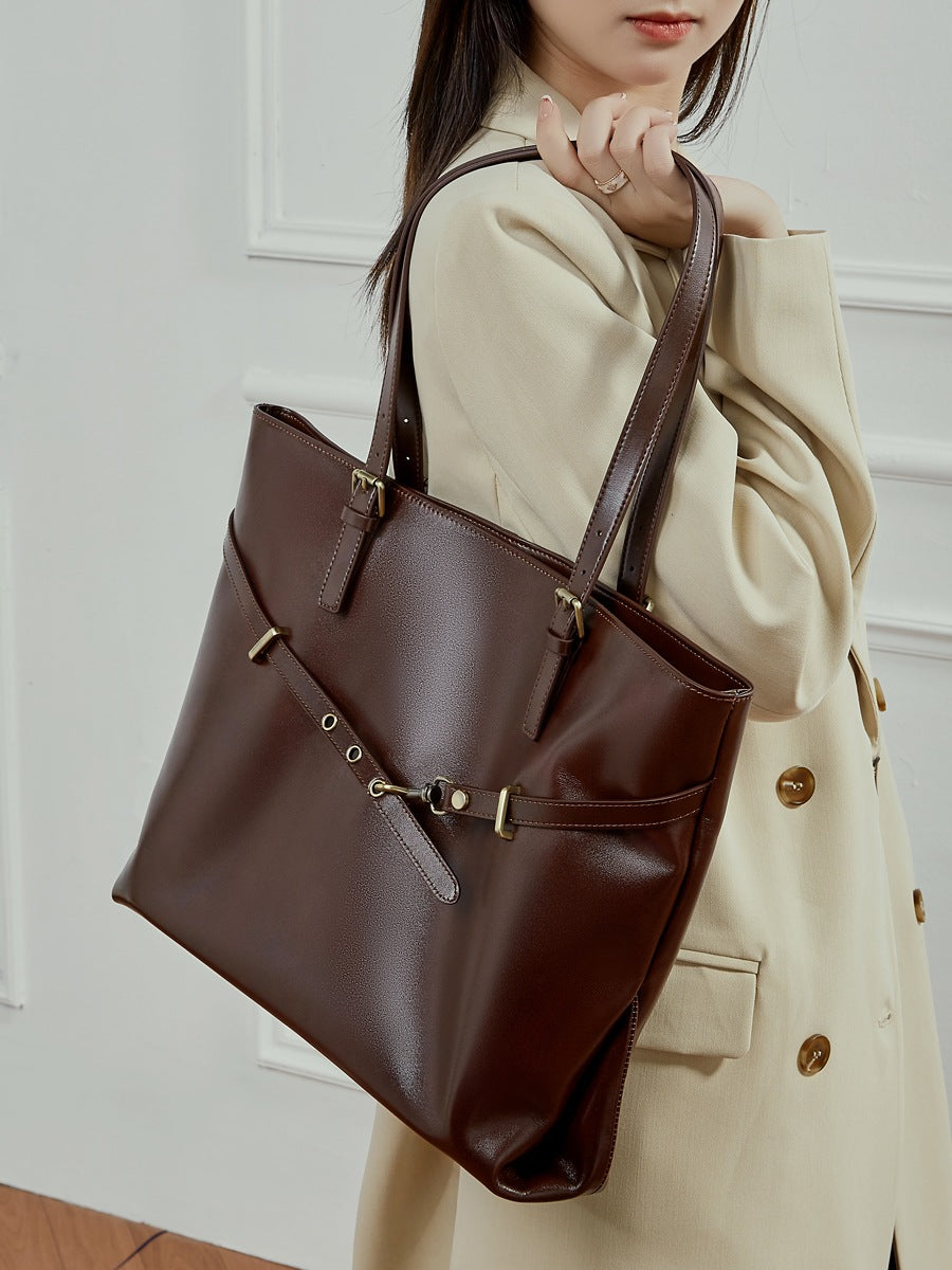 Sac Suthida chocolat porté à l’épaule avec un manteau beige