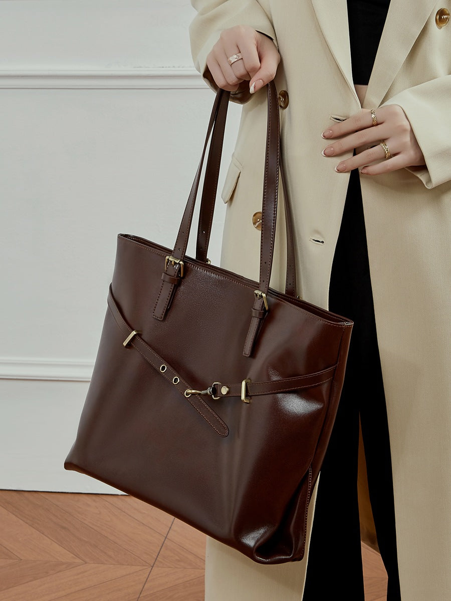 Sac Suthida chocolat porté à la main avec un manteau beige