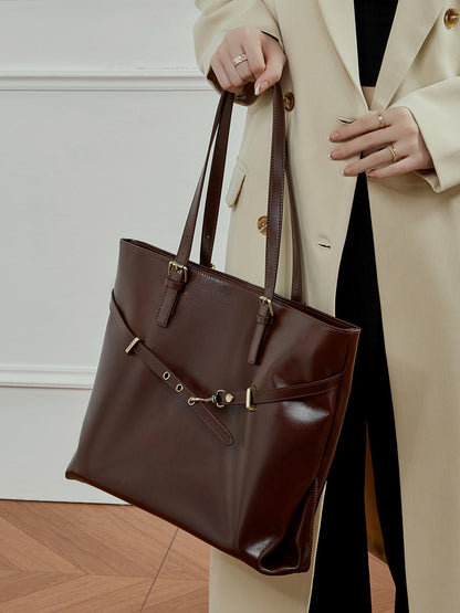 Sac Suthida chocolat porté à la main avec un manteau beige