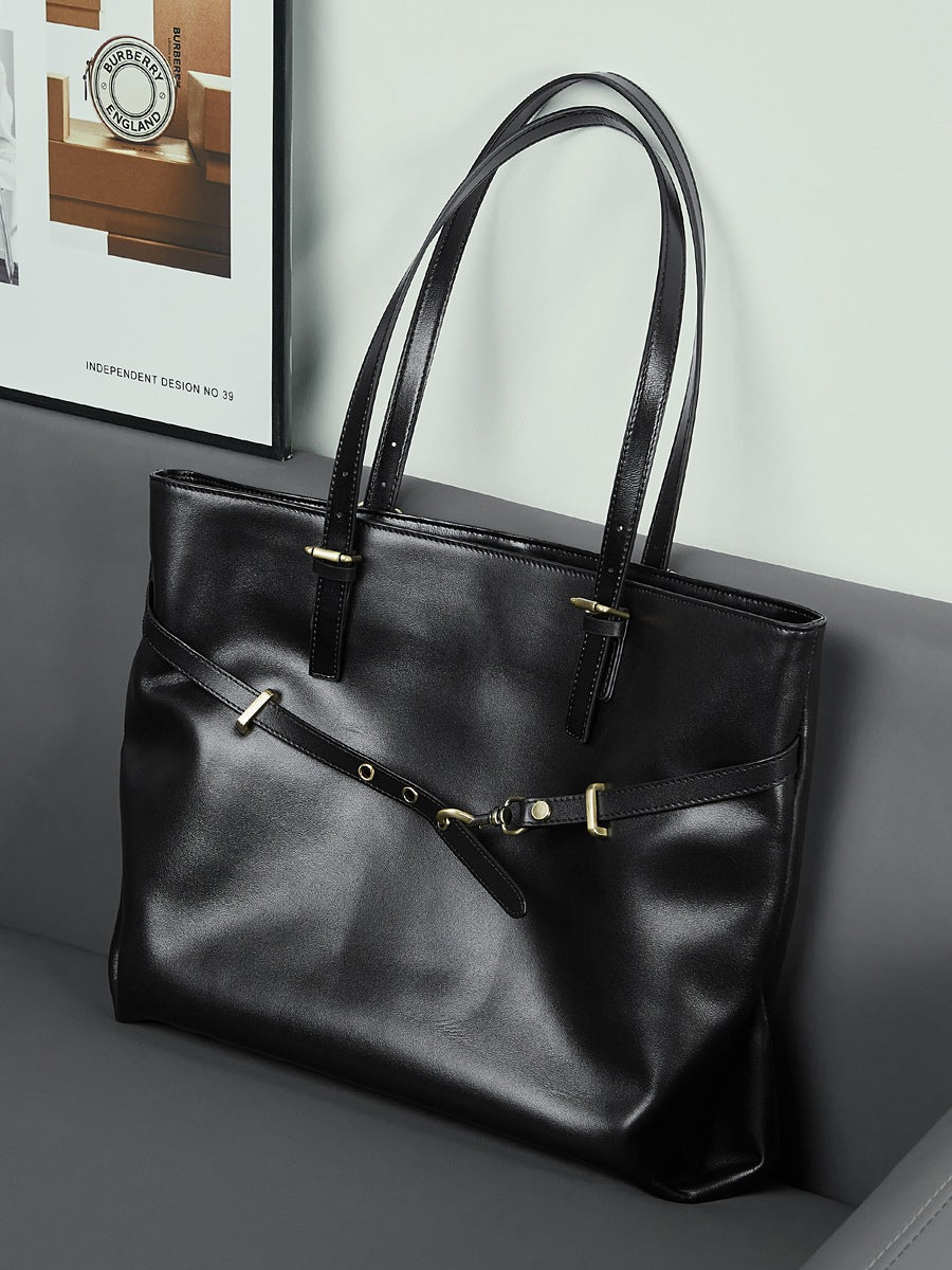 Sac Suthida noir posé sur une banquette grise