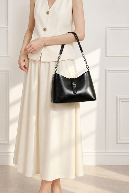 Sac Fanny noir porté au bras avec une tenue crème dans un intérieur clair