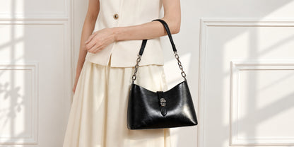 Sac Fanny noir porté au bras avec une tenue crème, vue large dans un intérieur clair