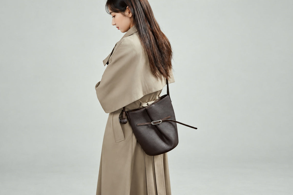 Sac Isabella marron café porté à l’épaule avec un trench beige