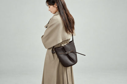 Sac Isabella marron café porté à l’épaule avec un trench beige