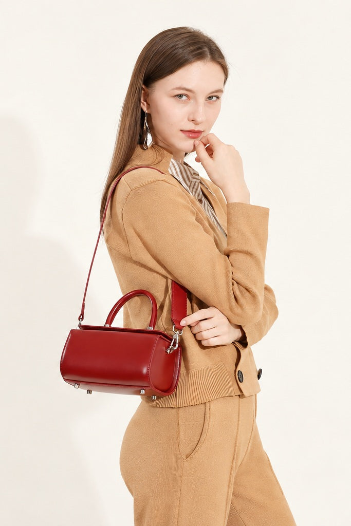 Selena rouge porté à l’épaule sur une tenue camel