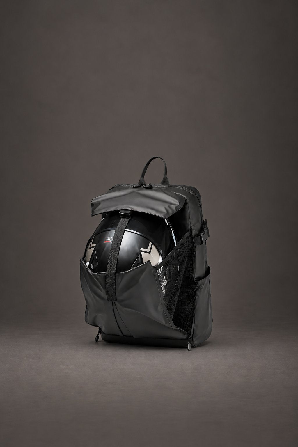 Sac à dos Jordan noir avec un casque intégral dans sa poche extérieure déployée